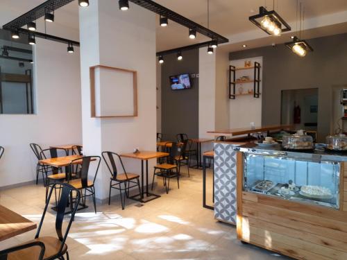 Casa Be Suites في روزاريو: مطعم بطاولات وكراسي وحوض سمك