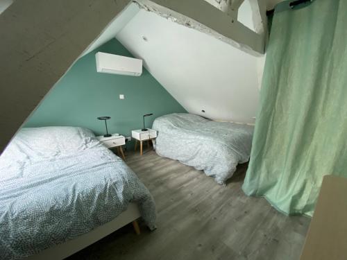 1 dormitorio en el ático con 2 camas y paredes azules en Logement Loire climatisé, La Halte de Cuze, aux abords de la Loire a vélo, en Huismes