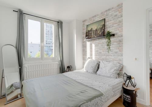 a bedroom with a white bed and a brick wall at Le PRIVILEGE aux PORTES de PARIS in Bagnolet