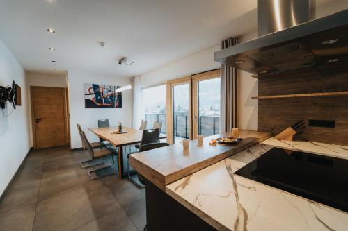 a kitchen with a table and a dining room at Apartklusiv Kaltenbach in Kaltenbach