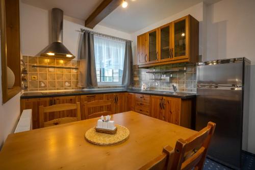 a kitchen with a wooden table with a cake on it at Penzion U Černého kohoutka in Zdíkov