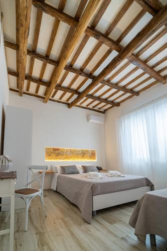 a bedroom with a large bed and a wooden ceiling at Villa White Luxury Residence in Marsala