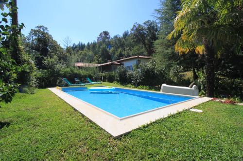a swimming pool in the yard of a house at Casa de Pedra, um refúgio para conhecer o Minho! in Ponte de Lima