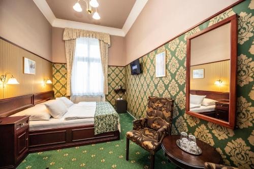 a bedroom with a bed and a mirror and a chair at Old Prague Hotel in Prague