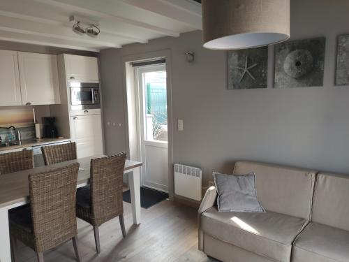 un salon avec un canapé et une table avec des chaises dans l'établissement SeaBreak4you, à Bredene