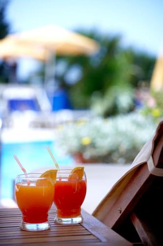 two glasses of orange juice sitting on a table at Sunshine Corfu Hotel And Spa in Nisakion