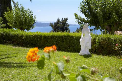 a statue of a woman in a yard with flowers at Sunshine Corfu Hotel And Spa in Nisakion