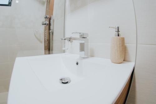 Un baño con un lavabo blanco y un espejo. en Wellness Resort Szécseny, en Jögödfürdő