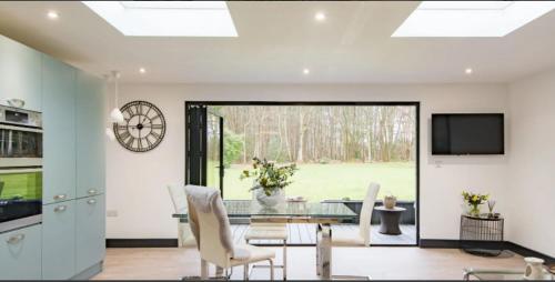 a living room with a glass table and a television at Little Seven Oaks in Langley