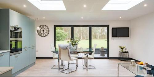 a kitchen with a glass table and chairs in a room at Little Seven Oaks in Langley