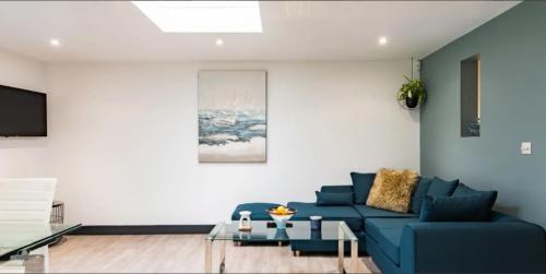 a living room with a blue couch and a table at Little Seven Oaks in Langley