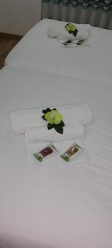 a white bed with towels and flowers on it at O Salgueiro in Melo