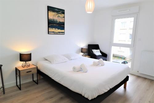 1 dormitorio con 1 cama blanca y 2 almohadas en LA DUCHESSE, T3 CENTRE - LOGGIA - PARKING - WIFI, en Vannes