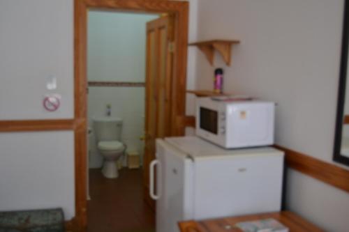克魯格斯多普的住宿－Lekkerrus guesthouse，厨房配有冰箱上方的微波炉