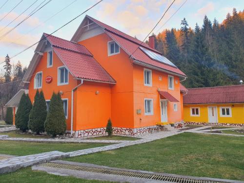 an orange house with a red roof at Pensiunea Marydor in Gîrda de Sus