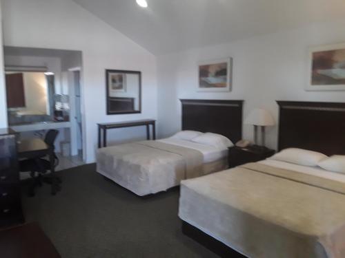 a hotel room with two beds and a desk at Italy Inn in Italy