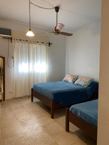 een slaapkamer met 2 bedden en een plafondventilator bij Departamento Hospital Privado Quality maternidad Con cochera in Cordoba