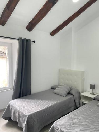a bedroom with two beds and a window at Casa Triacastela in Treacastela
