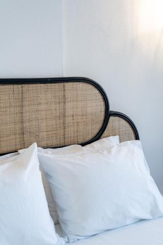 a bed with white pillows and a black headboard at Evanthia Best View Thirassia Island Hotel in Thirasia