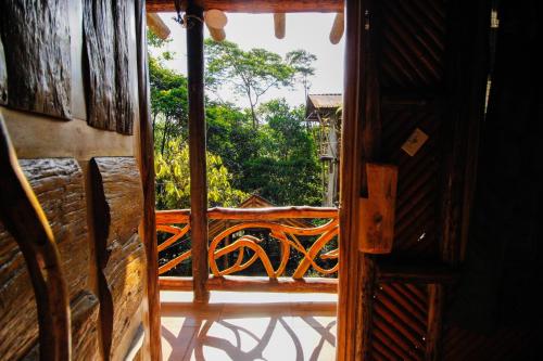 an open door to a balcony with a view at Hosteria Flor de Canela in Puyo