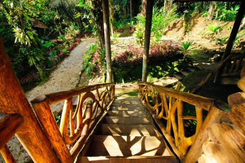 a wooden bench sitting next to a walkway at Hosteria Flor de Canela in Puyo