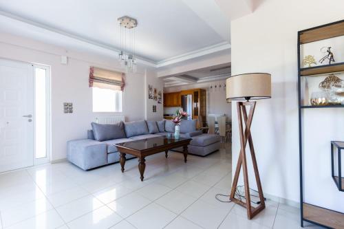 - un salon avec un canapé bleu et une table dans l'établissement Villa Elli, à Chersónissos