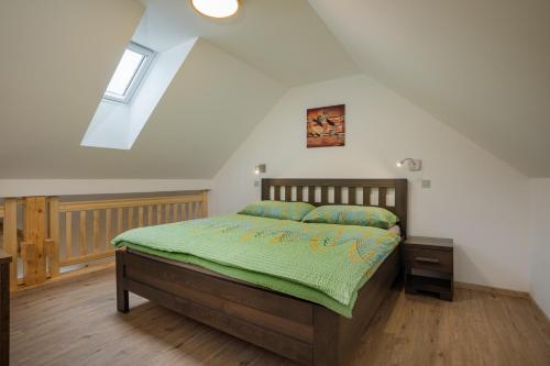 a bedroom with a bed with a green comforter at Penzion U Černého kohoutka in Zdíkov
