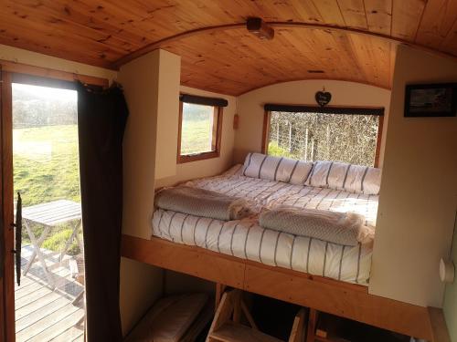 ein Bett im Inneren eines winzigen Hauses in der Unterkunft Tiny Home in Letterston