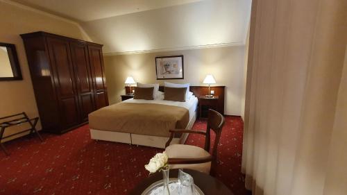 a hotel room with a bed and a table at Hotel Garden Club in Braşov