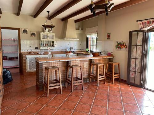 a kitchen with a counter and some stools in it at Casa Charo in Valle de Abdalagís