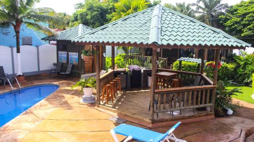 a gazebo with a table and chairs next to a pool at Bungalows Ballena in Uvita