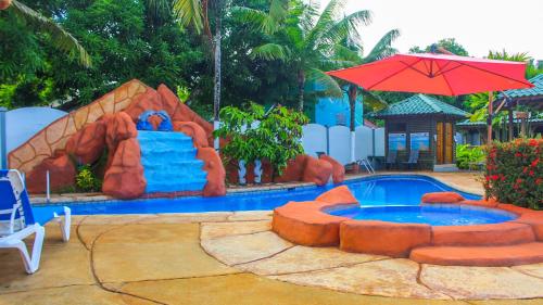 a pool with a water slide in the middle at Bungalows Ballena in Uvita