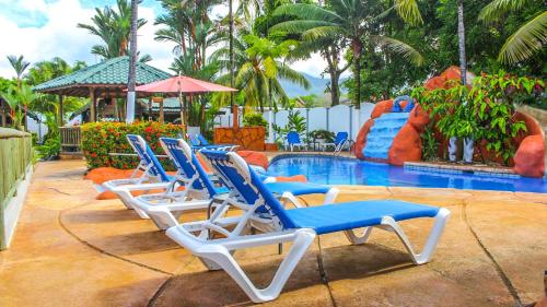 a group of lounge chairs next to a swimming pool at Bungalows Ballena in Uvita