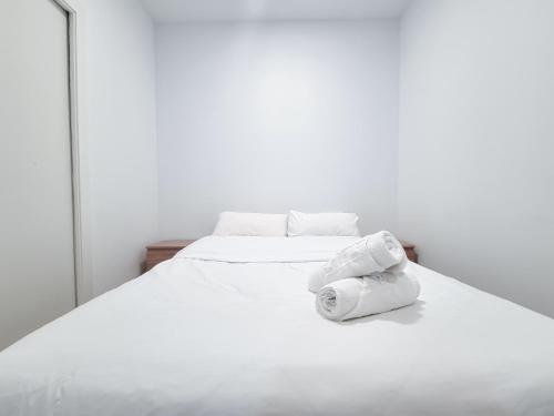 Una cama blanca con dos toallas enrolladas. en Metropolitan apartments, en Madrid