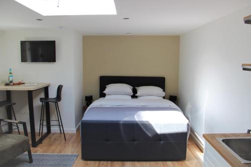 a bedroom with a bed and a desk and a table at Southpoint Zandvoort & private parking in Zandvoort