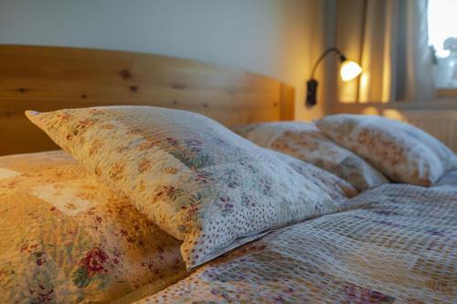 three pillows on a bed in a bedroom at Penzion U Černého kohoutka in Zdíkov