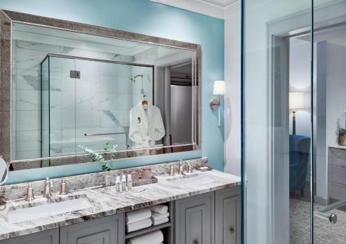 uma casa de banho com 2 lavatórios e um espelho grande em The Loutrel em Charleston