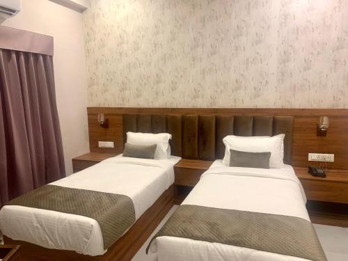 two beds in a hotel room with at Hotel Mumbai House-LIG Behind CHL Hospital in Indore