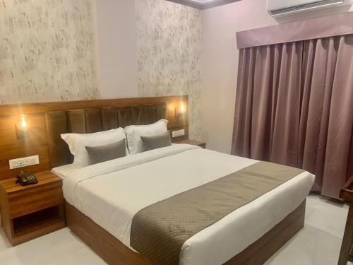 a bedroom with a large bed and a window at Hotel Mumbai House-LIG Behind CHL Hospital in Indore