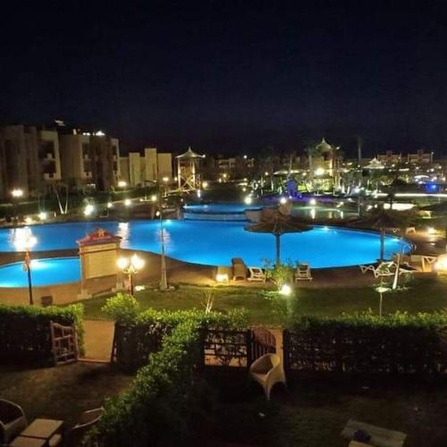 a large swimming pool at night with a city at Blue Bay Asia Sokhna Aqua park بلو باي اسيا العين السخنه - عائلات فقط in Ain Sokhna