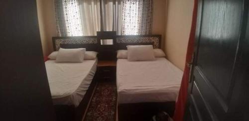 two beds in a small room with two windows at Blue Bay Asia Sokhna Aqua park بلو باي اسيا العين السخنه - عائلات فقط in Ain Sokhna