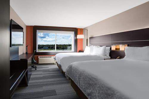 a hotel room with two beds and a television at Holiday Inn Express & Suites Sanford - Lake Mary by IHG in Sanford