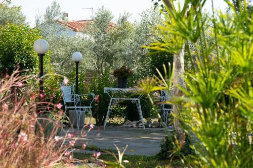a patio with two chairs and a table in a garden at Nice house by the sea! in Epanomi