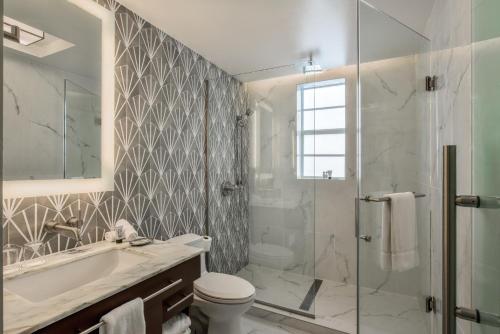 La salle de bains est pourvue d'un lavabo, de toilettes et d'une douche. dans l'établissement Hotel Breakwater South Beach, à Miami Beach