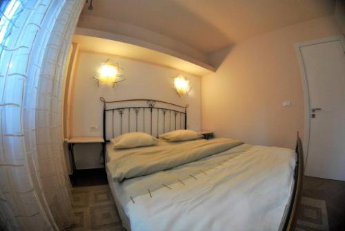 um quarto com uma cama grande e lençóis brancos em Modern & Central Apartment in North of Bucharest em Bucareste