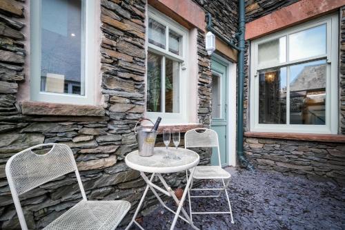 two chairs and a table in front of a building at Glen Wynne Windermere - FREE off-site Health Club access with Pool, Sauna, Steam Room & Gym Short 5 Minute Drive Away in Windermere