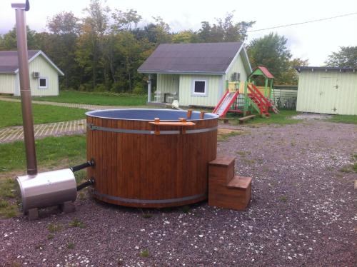 a large wooden tub sitting in a yard with a playground at Valaste Puhkeküla in Kohtla-Järve