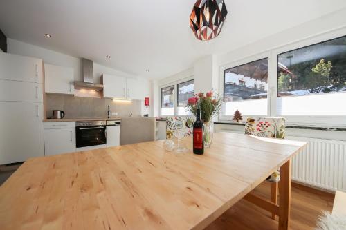 a kitchen with a wooden table with flowers on it at Ferienwohnungen Wartbichler in Lofer