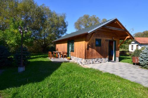 a small wooden building with a grassy yard at chatka Tatralandia 433 Sofinka in Liptovský Mikuláš