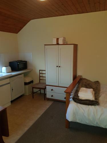 1 dormitorio con 1 cama, armario y microondas en Amazingly quiet and peaceful studio getaway. en Woodhall Spa